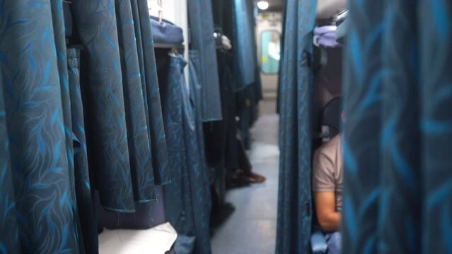 4k video. The interior of a sleeping coach on a train typically includes rows of beds or berths, with curtains or partitions for privacy. The beds can be folded up to form seating during the day. 