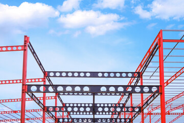 Red and black Castellated Beam metal of Industrial Building Structure in Construction Site against blue sky background