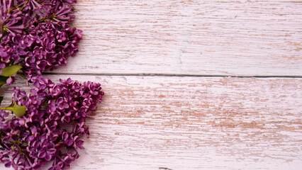 Beautiful purple-lilac lilac flowers, on a white wooden background. Flat apartment, top view with copy space. A postcard for Mother's Day, Valentine's Day.
