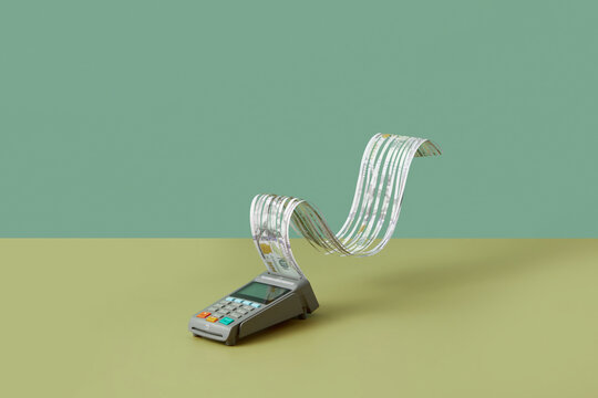 POS terminal with cut dollar banknote receipt.