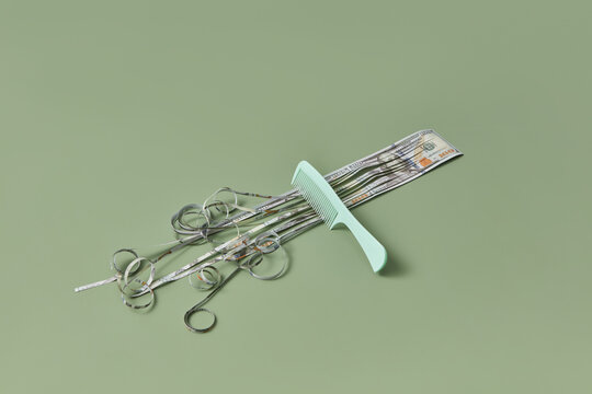 Extended dollar bill, cut into strips with comb.