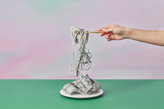 Shredded dollars on fork in woman's hand.