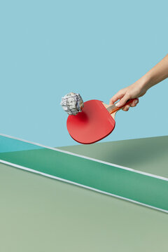 Dollar ball for ping-pong with racket in hand.