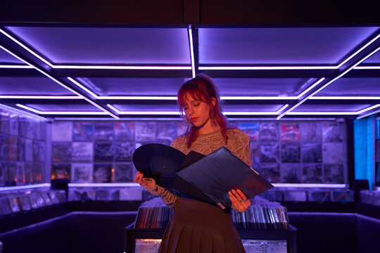 Young woman examining vinyl discs