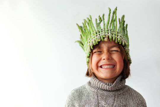 Smiling kid with a veggie crown 