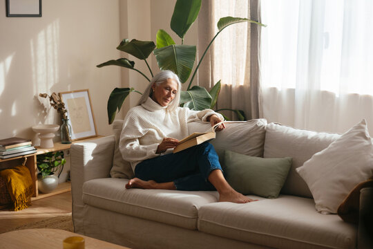 Woman reading book in living room
