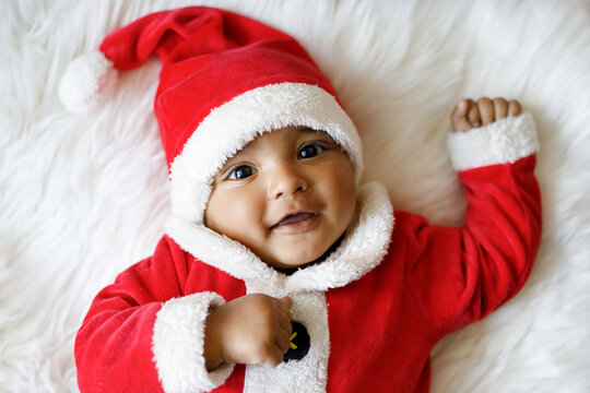 Cute baby wearing santa claus costume smiling at camera