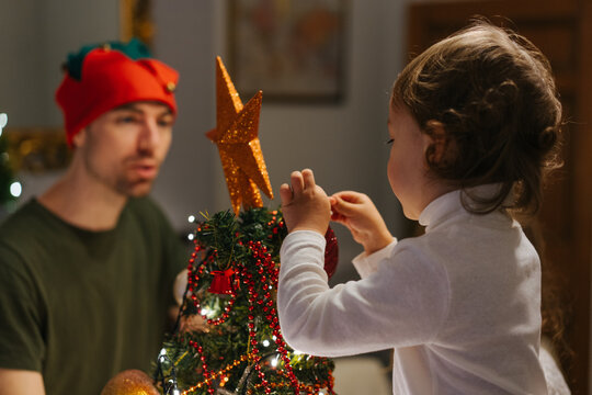 Father and son decorates the Christmas tree