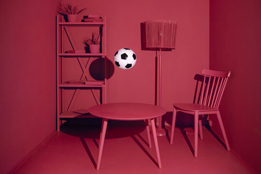Conceptual still life with a soccer ball in a red monochrome room