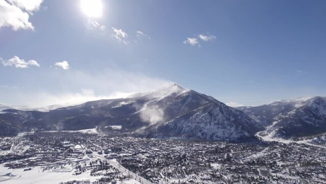 Snowy Mountains with Village at the base.  Silverthorne, Colorado. Daytime. Aerial Drone Footage.