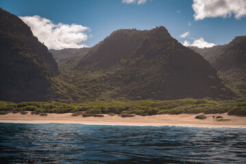 2021-10-07 THE NA PALI COAST OFF OF KAUAI HAWAII WITH LUSH GREEN MOUNTAINS AND A NIC EBEACH AND CLEAR PACIFIC OCEAN AND NICE SKY