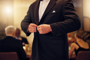Suit, formal and man tie the button of his jacket at a fancy dinner, party or event banquet....