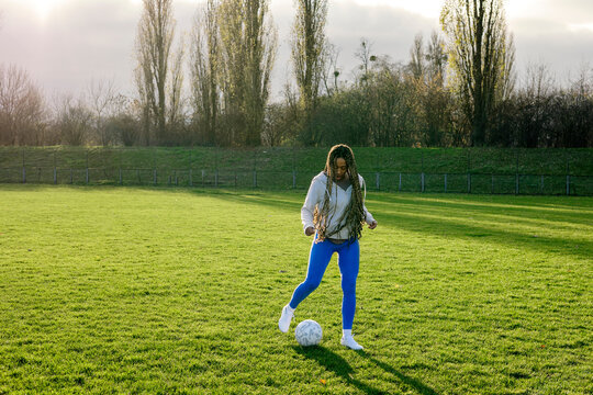 A woman alone at the stadium trains with a soccer ball