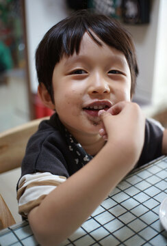 Asian little boy with food on table

