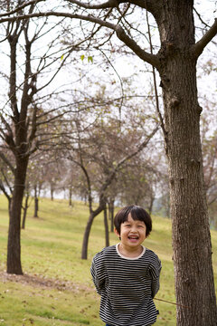 Little Asian boy, playing in the autumn forest
