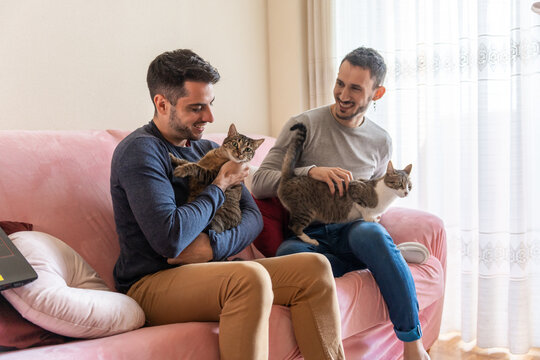 Gay Couple With Cat On The Couch.