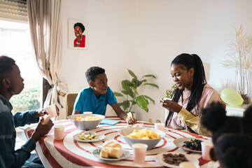 Teenage cousins reunited celebrating a birthday at home