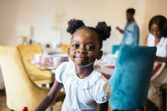 Portrait of a little black girl with bows looking at camera.