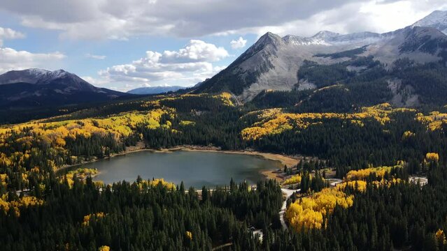 Drone flying over Lost Lake with fall tree colors and mountains, on Kebler pass Colorado. 