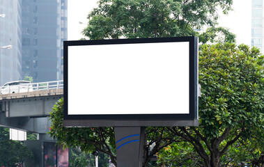 Fototapeta premium Outdoor pole billboard with mock up white screen on city view background and clipping path