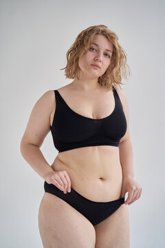 Curvy woman adjusting black panties