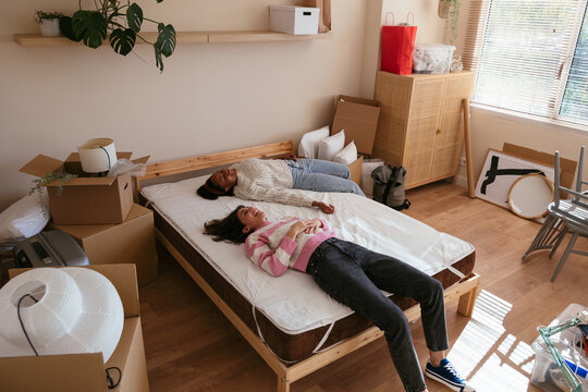 Female flatmates unpacking boxes at new home