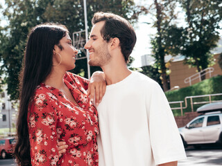 Smiling beautiful woman and her handsome boyfriend. Happy cheerful family. Sexy couple posing in the street at sunrise. During romantic date at sunny summer day outdoors. Looking at each other