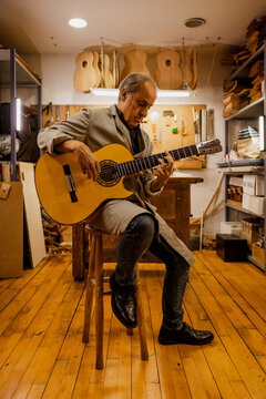 Luthier testing a finished custom classical guitar