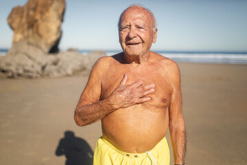 Naklejka premium senior man in swimming trunks on the beach