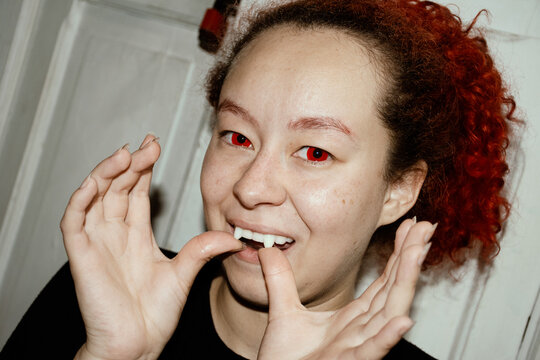 Putting on fake vampire fangs