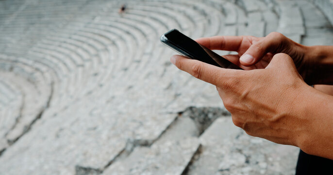 using his phone in the Ancient Theatre of Epidaurus, banner format
