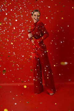Happy woman with confetti on a red background