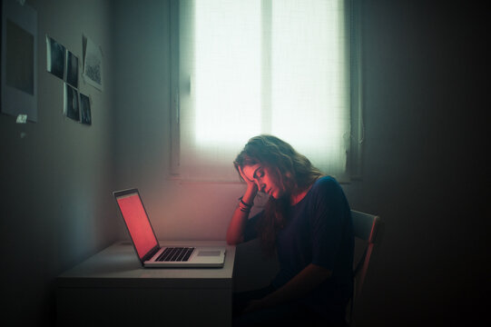 Cinematic portrait of depressed woman with laptop