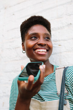 Smiley African-American woman sending a voice note
