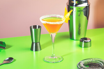 Sidecar alcoholic cocktail with cognac, liqueur, lemon juice and ice. Pink and green pop background, copy space