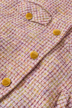 Yellow buttons on sweater detail.