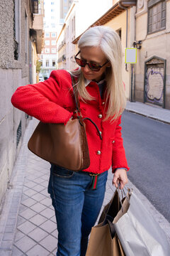 Woman With Red Jacket Searching On Her Handbag.