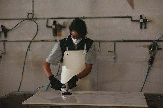 Female polishing marble in workshop