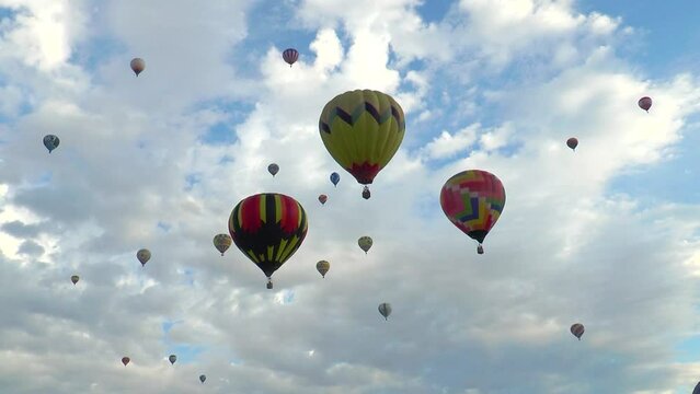 Large multi-coloured vibrant balloons slowly rising against a beautiful sky. Flight hot air balloons in Cappadocia. Amazing visual show, view, experience. Travel, adventure, festival.