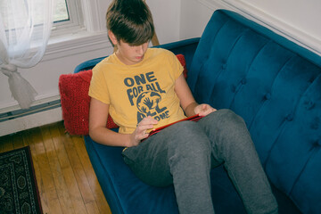 tween on tablet on couch