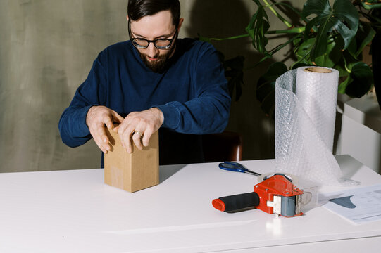man taping up a package for shipping