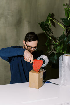 man taping up a package for shipping