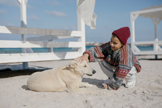 boy petting a white dog