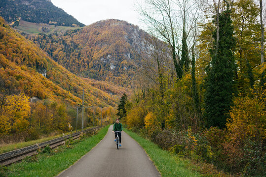 Man riding bike near autumn forest