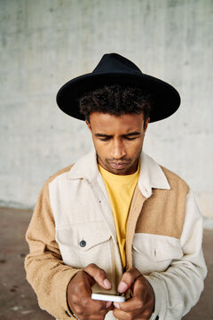 Young man with hat checking his phone 