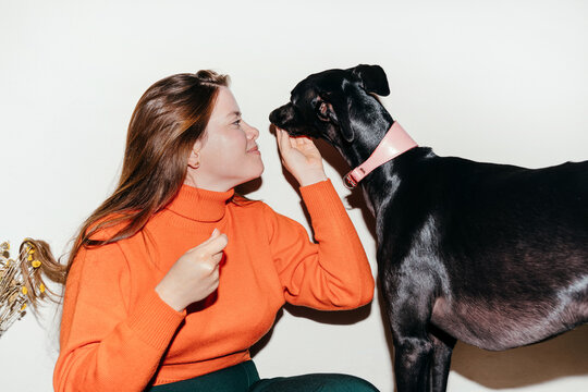 Woman and black greyhound dog
