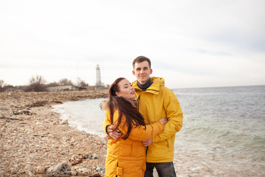 man huffing with woman in the beach at cold waether