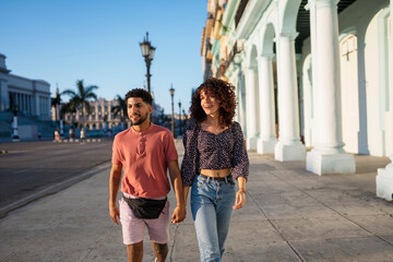 Happy couple strolling on street in city