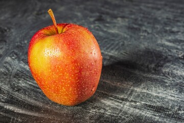 Drops of water on a ripe apple - appetizing and healthy food