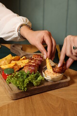 delicious grilled meat roll with potato, lettuce, tomato on a wooden tray